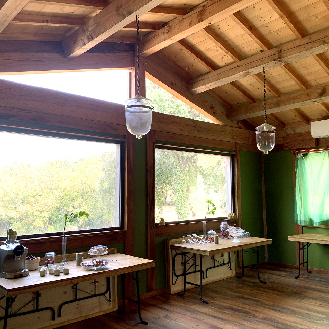 tables devant grandes vitres donnant sur la forêt de provence avec catering pour lancement de produit en provence